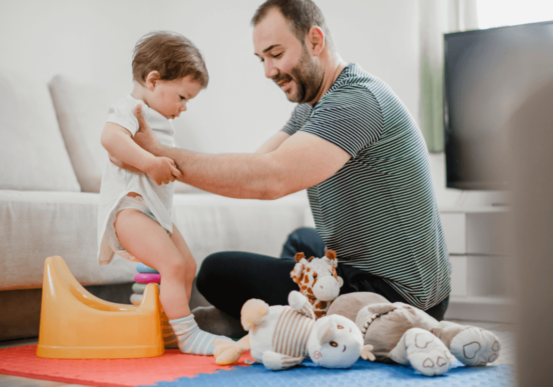 Dad putting child on potty 
