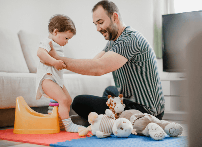 Dad putting child on potty 