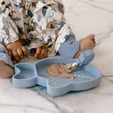 Child sitting on a Marble surface with a Sarah Shark Learning Utensil and Snack Plate