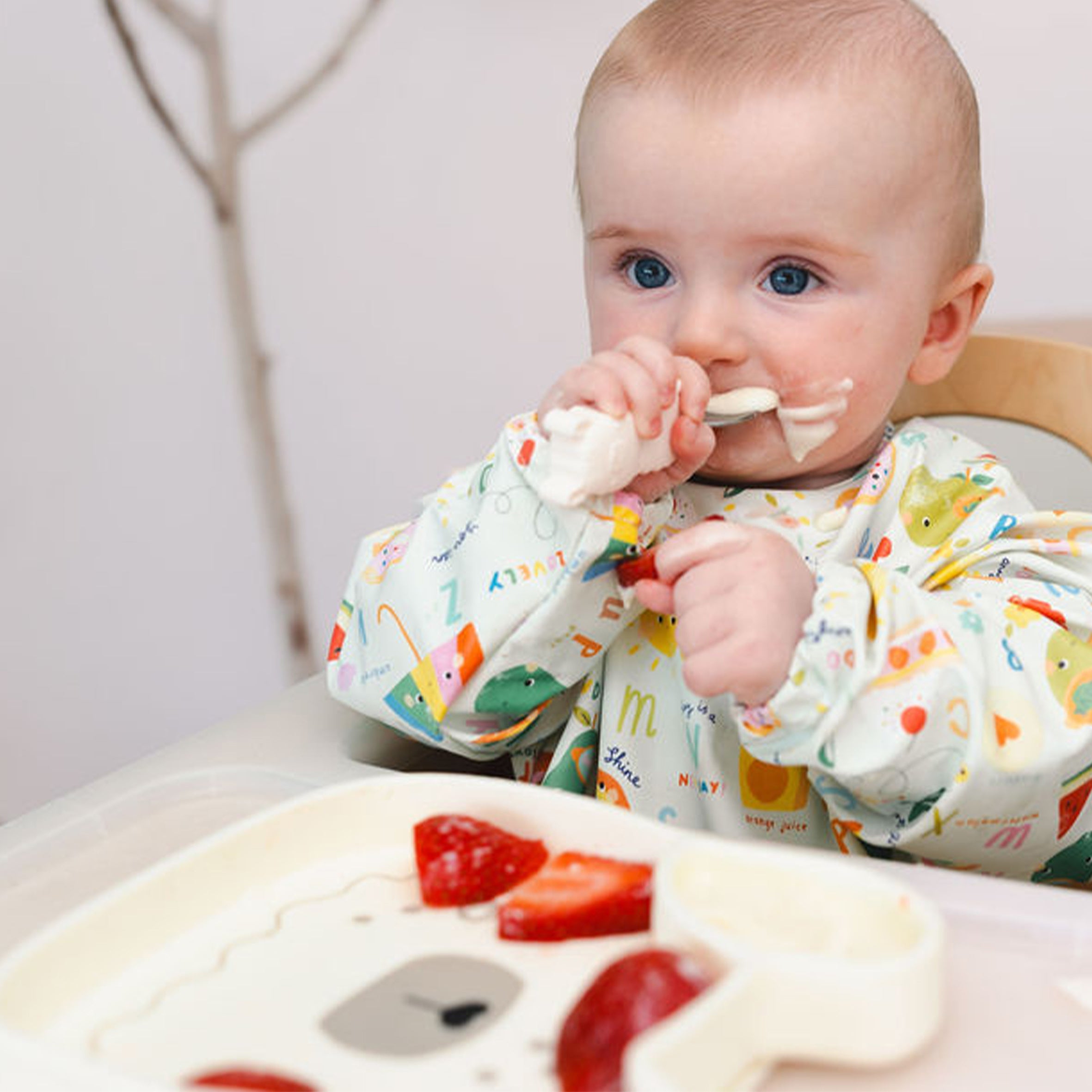 Baby eating yoghurt of a Lane Llama Snack Plate