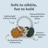 Liam Lion teething charms with text highlighting its features on a light blue background