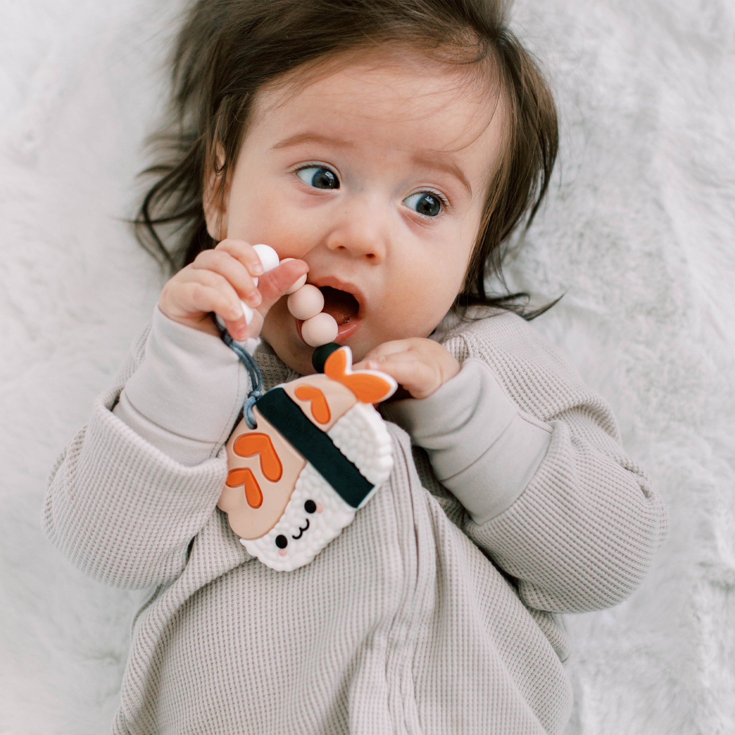Baby with a Sushi teething clip attached to there clothes 