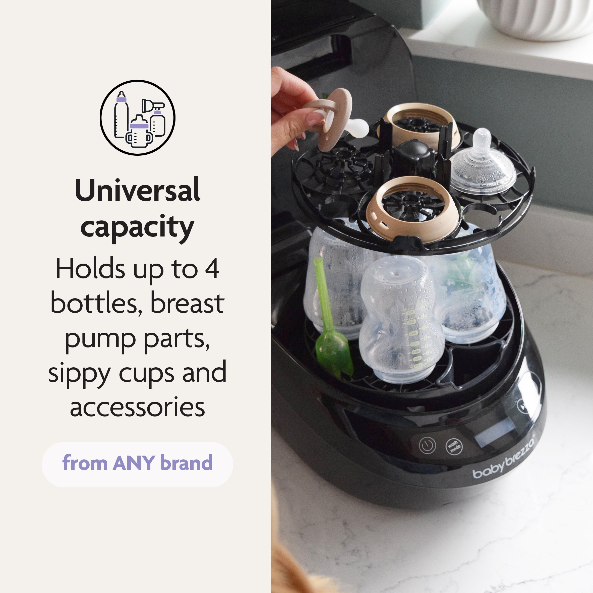 A person places a bottle accessory into the Baby Brezza Bottle Washer Pro® - All Black, filled with bottles and parts. Text: Universal capacity—washes up to 4 bottles, sippy cups, pump parts & accessories from any brand.