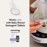A detergent tablet dissolves as a hand loads bottles into the Baby Brezza Bottle Washer Pro® - All Black. Text reads, “Works only with Baby Brezza Detergent Tablets.” The detergent tablets box appears at the bottom.