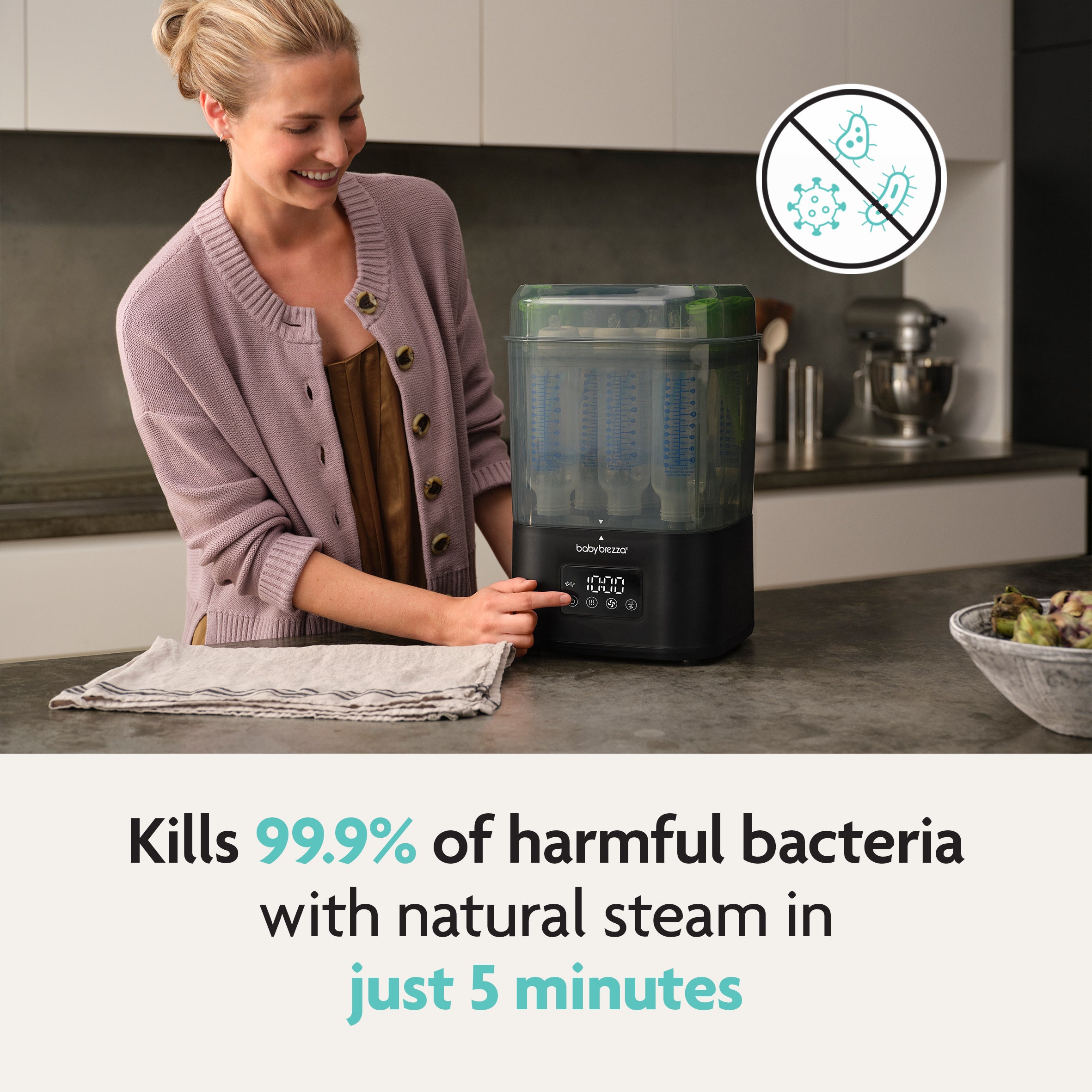 A smiling woman uses the Baby Brezza SuperQuick Steriliser Dryer in a modern kitchen. Text: Kills 99.9% of harmful bacteria with natural steam in just 5 minutes. Features largest capacity for easy, effortless sanitizing. Brand: Baby Brezza.