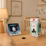 A softly lit nursery showcases the Cheeky Rascals UK Newborn Essentials Bundle—featuring the Rockit Wooshh, baby rocker, and Izmi Essential Wrap—ideal for expecting parents or as a thoughtful Baby Shower gift.