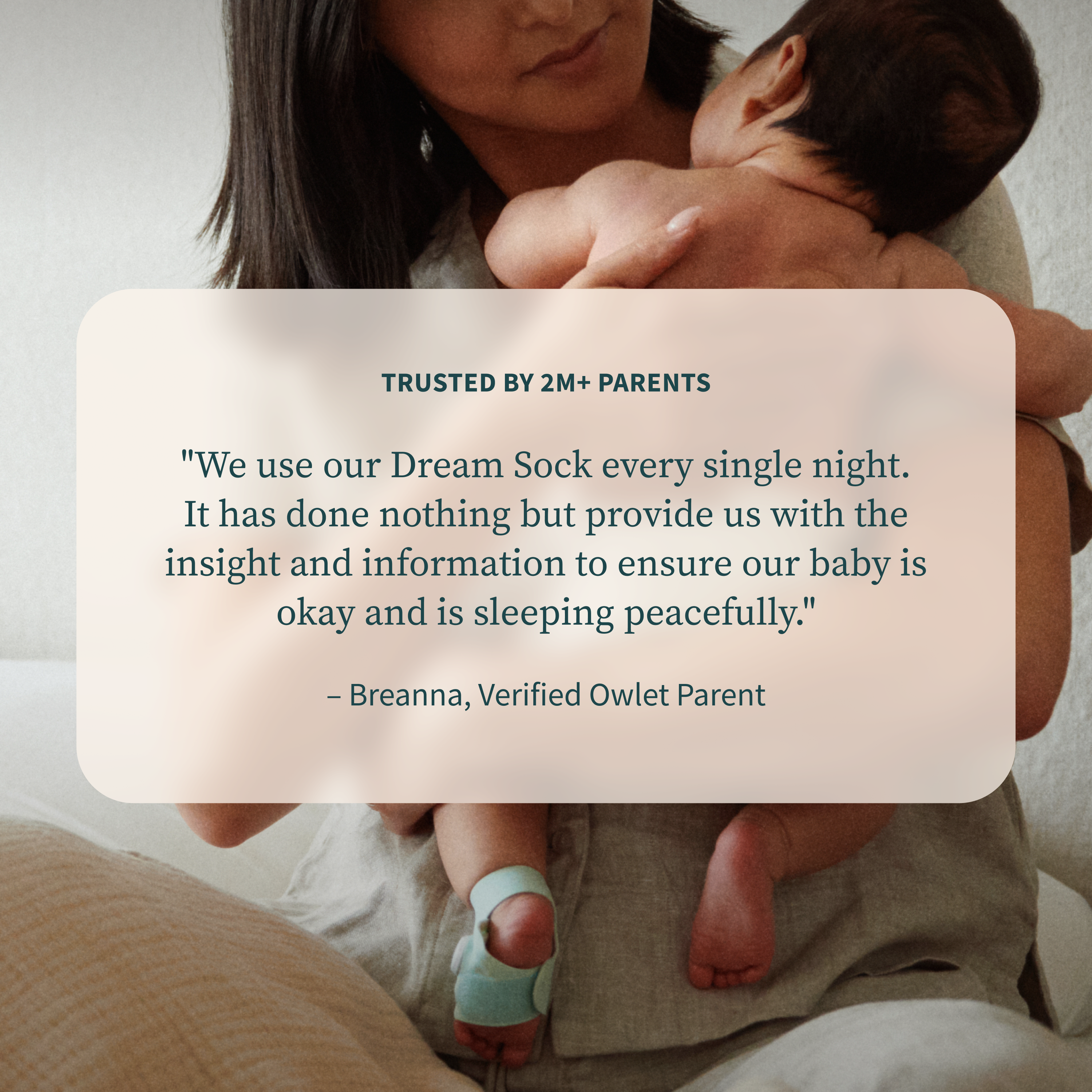 An adult holds a baby wearing a foot monitor, shown alongside a parent’s testimonial and an Owlet Dream Sight™ Camera Stand.